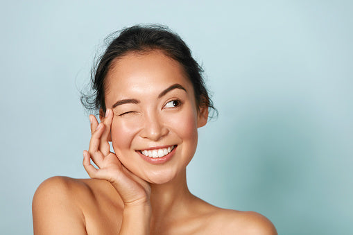 Woman applying skincare to eyelid