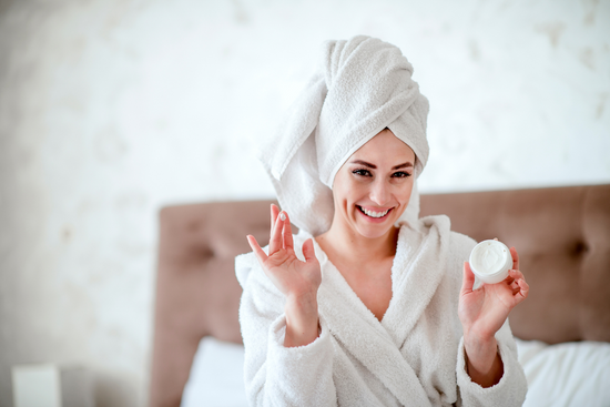 Smiling woman applying barrier cream to her face