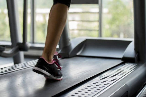 Close-up of legs walking on a treadmill