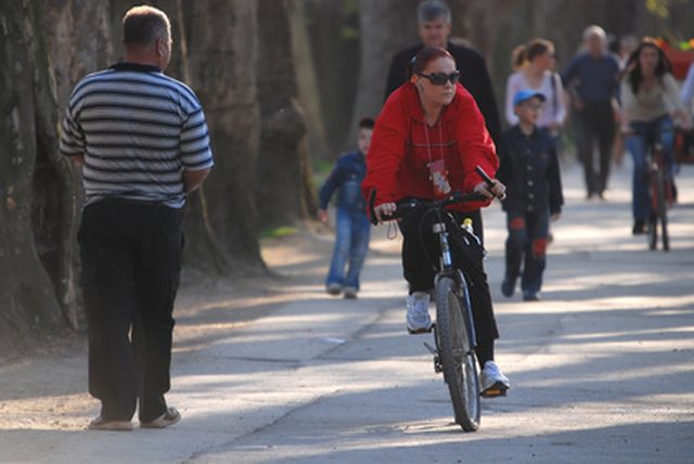 An older woman and man are riding their bicycles.