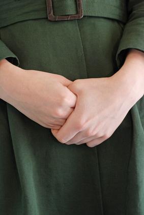 Close up of woman grasping her fingers.