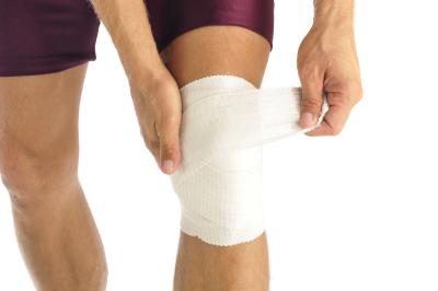 Man wrapping knee in bandage.