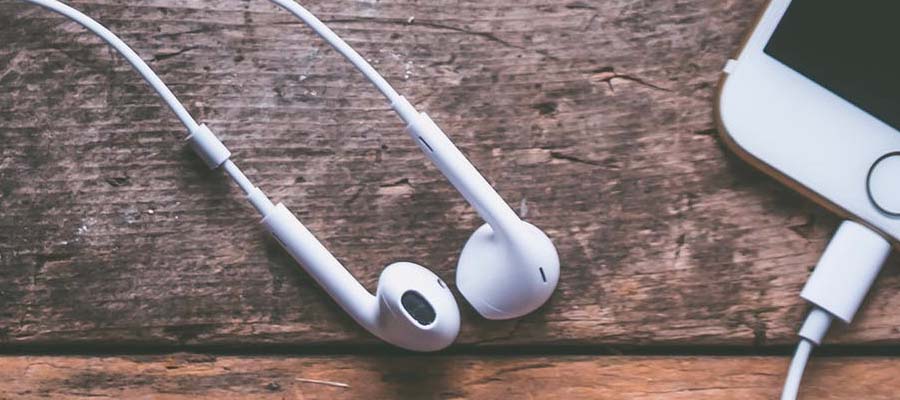 White earphones laying on the wooden table