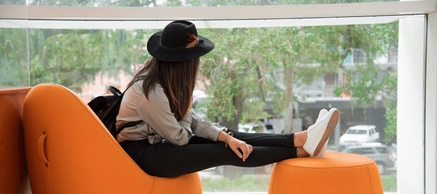 Woman sitting by window at remote working location 