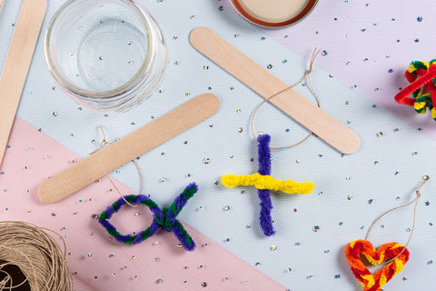 Overhead shot of pipe cleaner fish and cross on sparkle background for borax crystal Sunday school craft