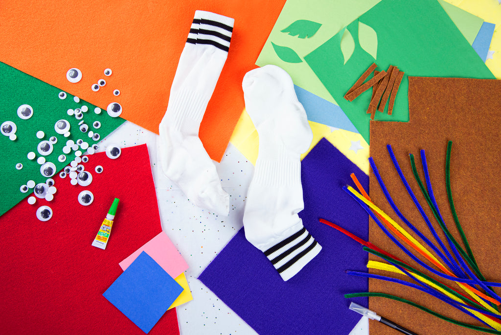 colorful image of sock puppet making materials with felt squares, googly eyes, and pipe cleaners