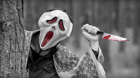 Man with Scream Mask and Bloody Fake Knife Behind Tree