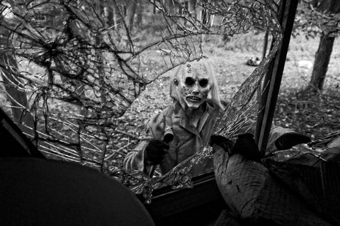 Halloween concept. Close-up portrait Man maniac in white mask and black  hood in the forest under the blue light of the moon at night, look. Stock  Photo