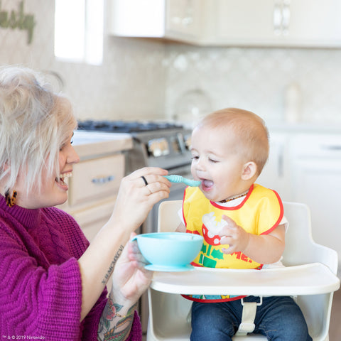 woman spoon-feeding toddler 