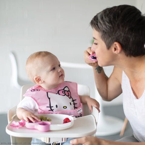 woman showing baby how to eat 