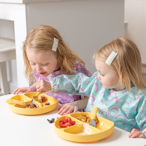 toddlers using utensils while eating 