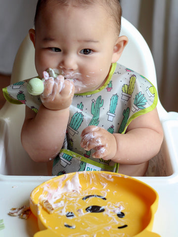 baby eating from winnie the pooh toddler plate