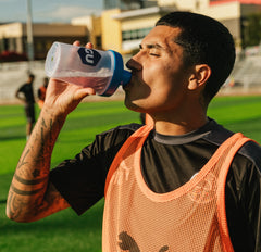 soccer player drinking from a blender bottle