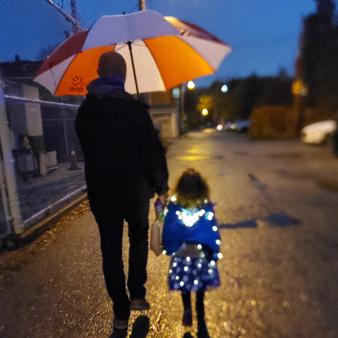 father and daughter walking at night in rain