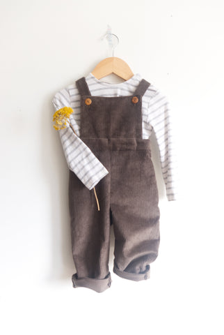 green corduroy overalls on wall with yellow flower