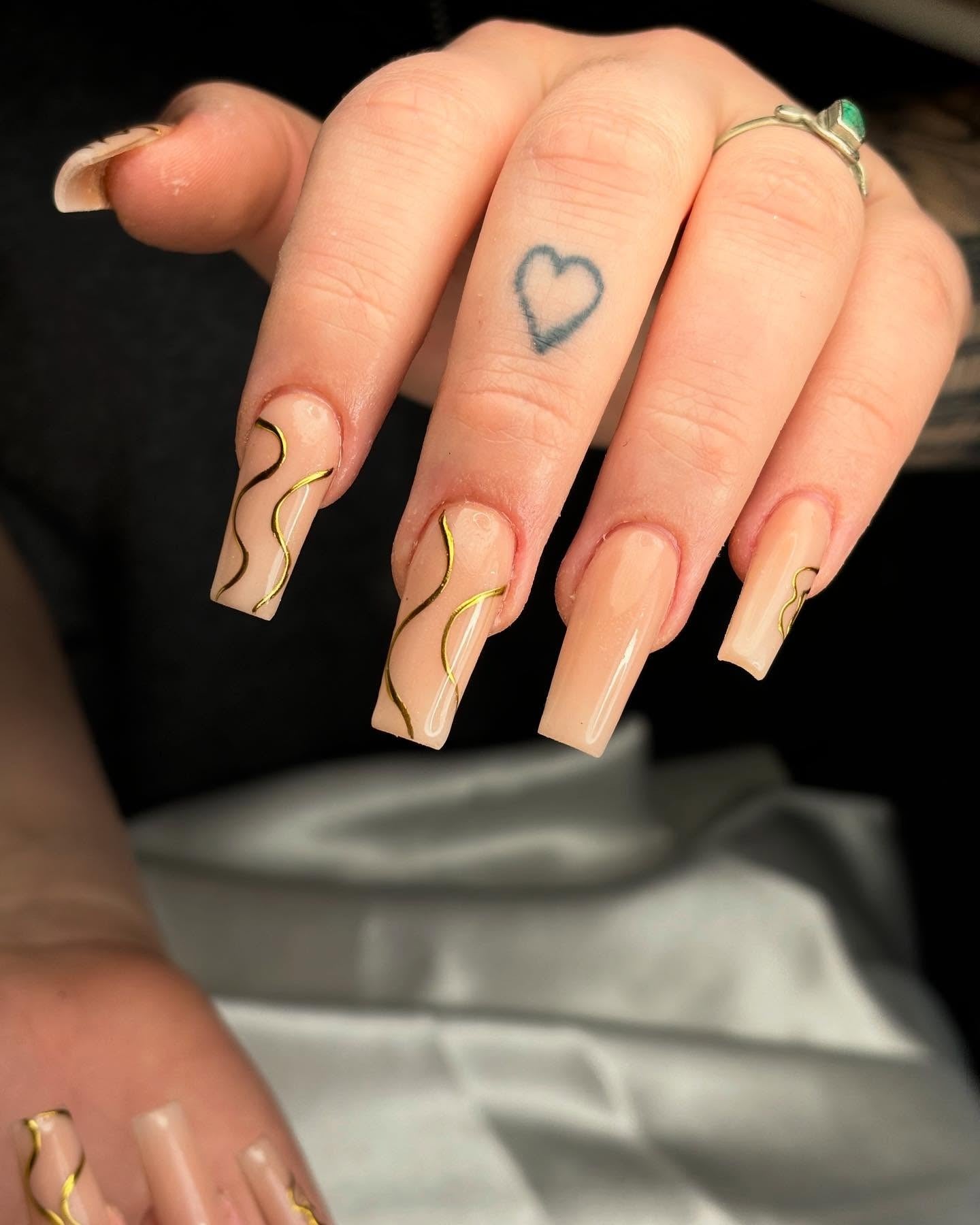 15. Nude Coffin Nails with Gold and Black Wavy Lines - line nail ideas