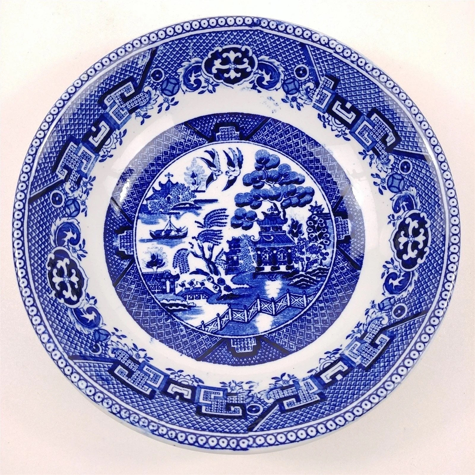 A plate with a blue and white landscape depiction and border.