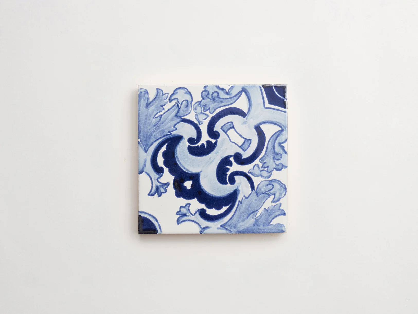 blue and white hand painted tile with floral motifs