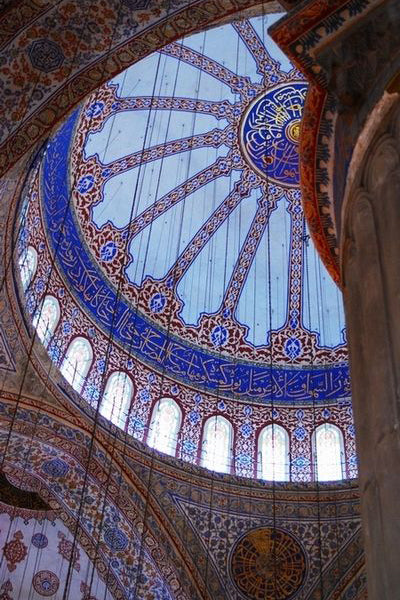 The interior of a domed roof in glass and tile at the blue mosque.