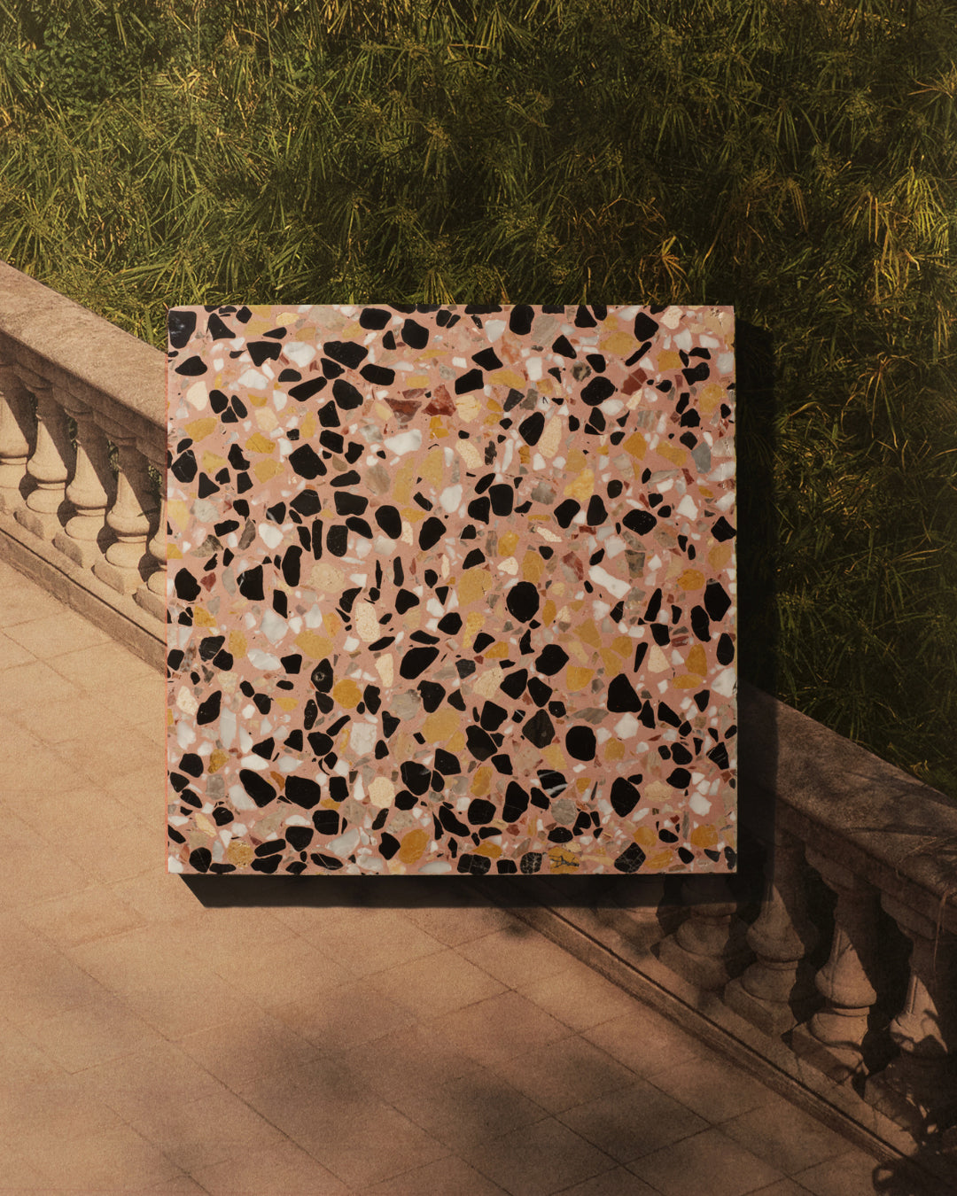 A terrazzo tile in front of an inspiration image of a bridge.
