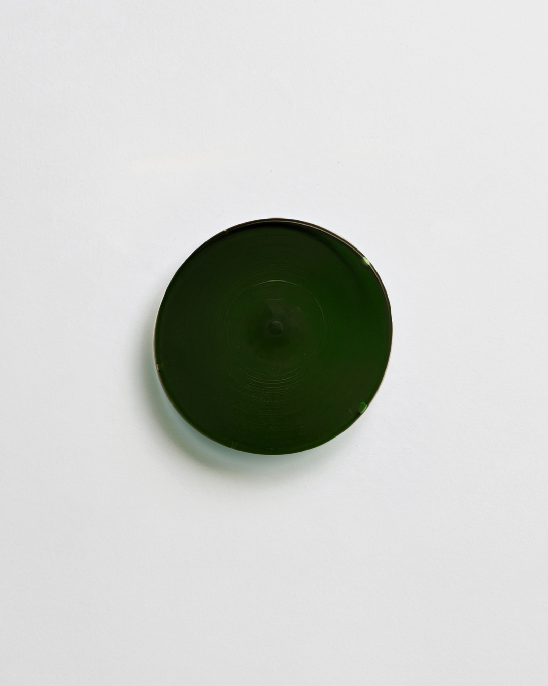 A forest green circular glass tile.