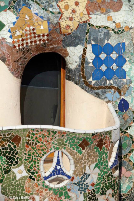 A curving wall covered in colorful broken tile.