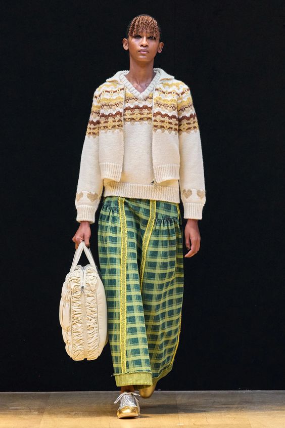 woman on runway wearing knit sweater and green plaid pants