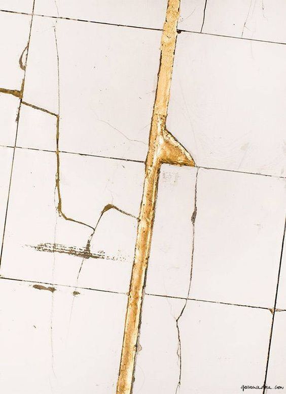 gold lacquer filling in cracks on a white surface