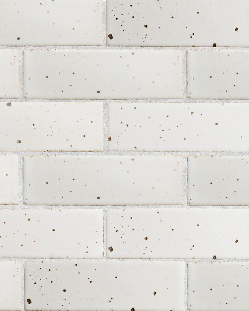 Closeup of white glazed brick tile wall.