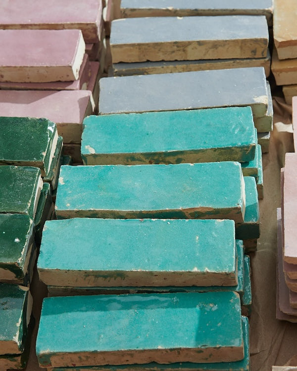 stacks of colorful rectangular zellige tiles in teal, grey, pink, and green
