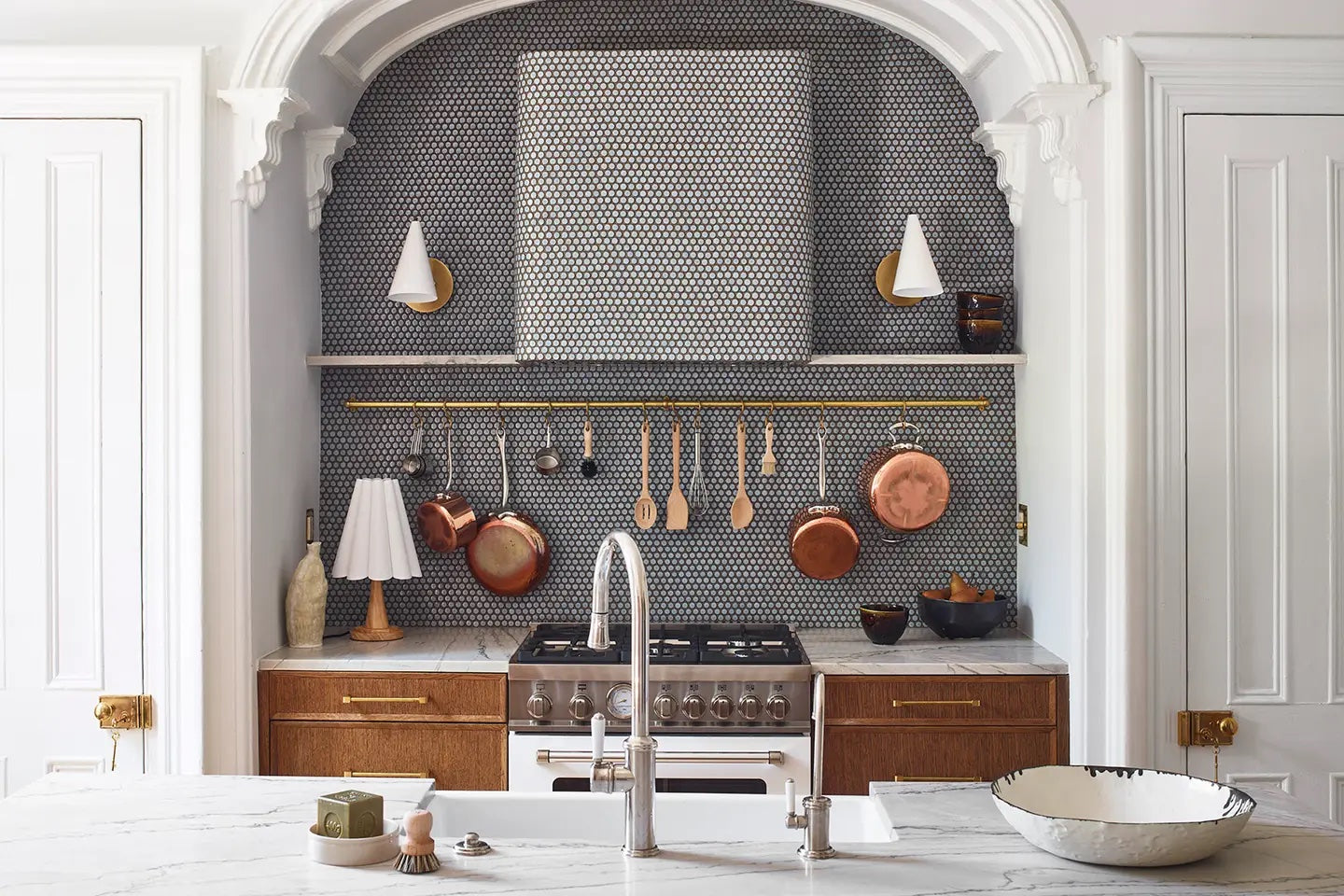 A kitchen wall with a penny round tile backsplash and wall.