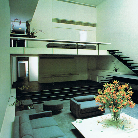 a 70s apartment with a sunken living room and floating stairs.