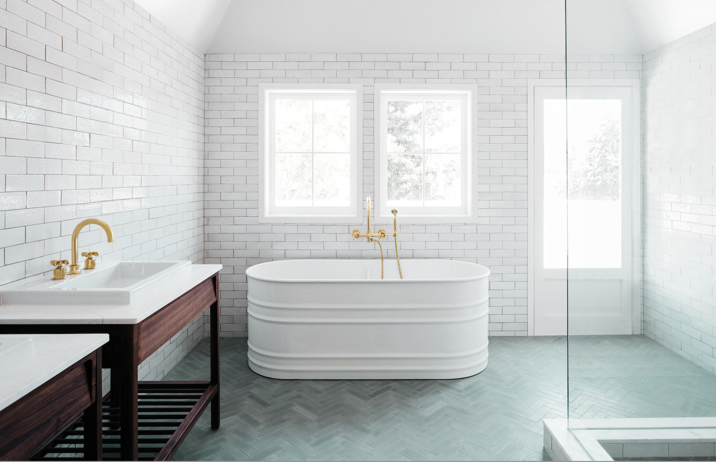 white bath tub with herringbone tile flooring