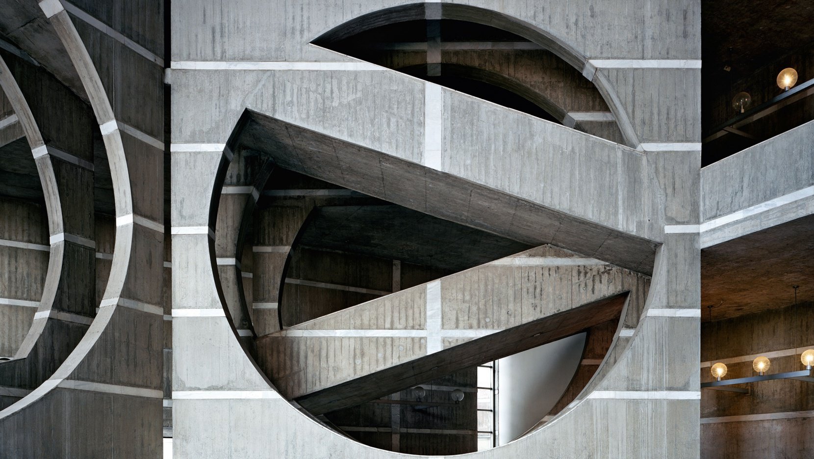 Concrete walls with large circle gaps surrounding staircases.