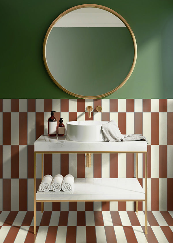 Earth colored bathroom sink area with a checkered white and brown cement tile backsplash and green painted walls.