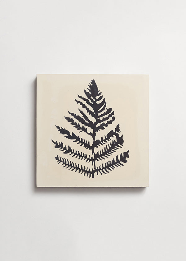 Single Erica Tanov cement tile featuring a black fern against a cream background.