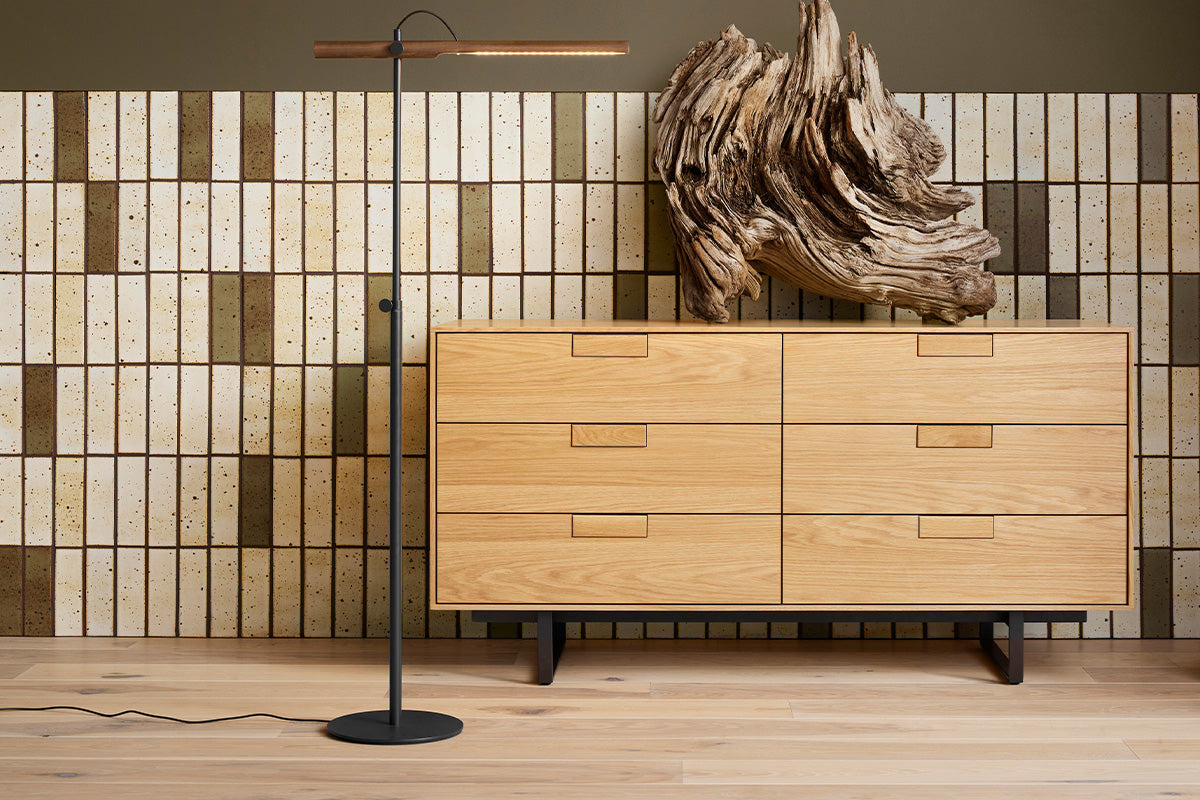 Modern living area with wooden credenza, neutral glazed brick tile on the lower wall, and green paint above.