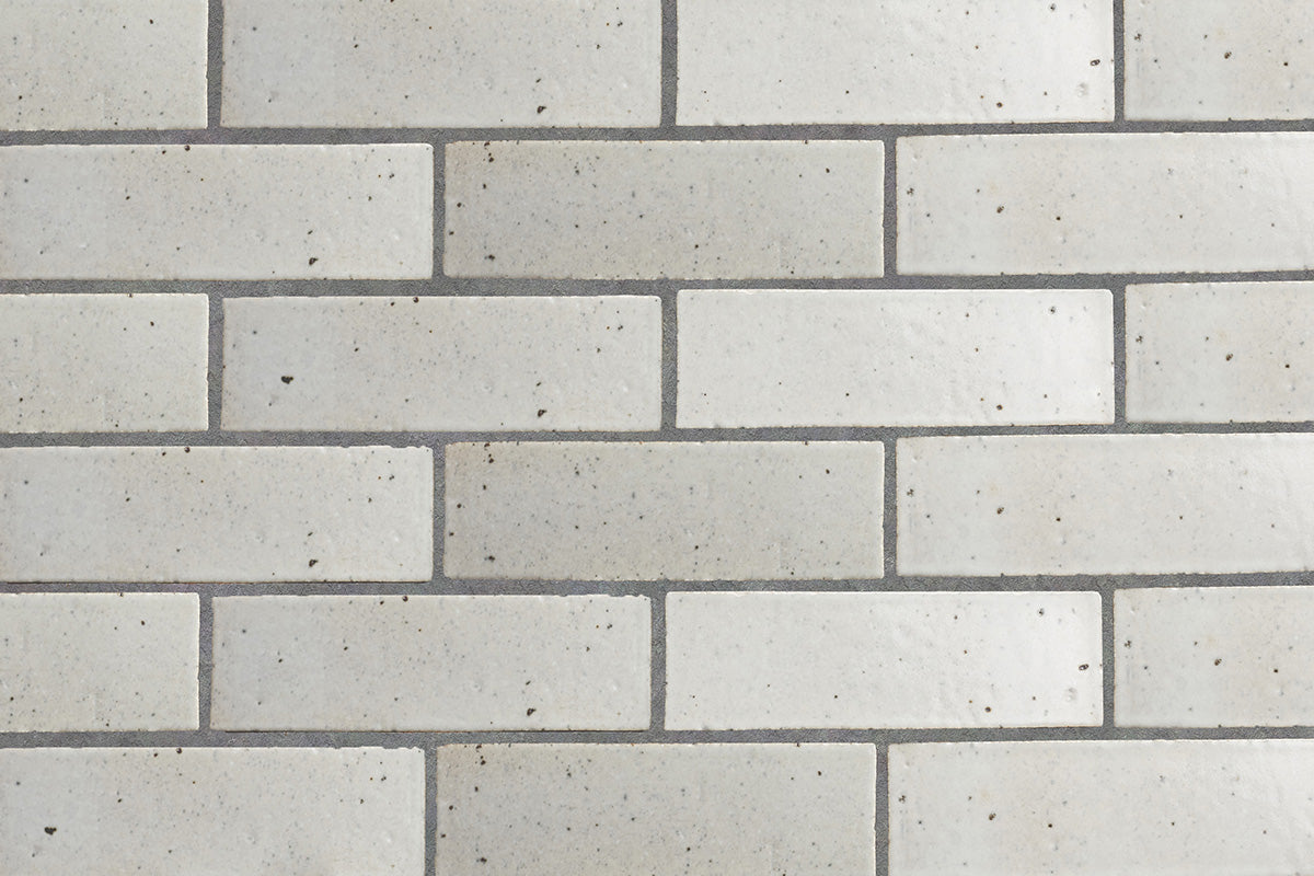 White glazed brick tile wall in running bond layout.