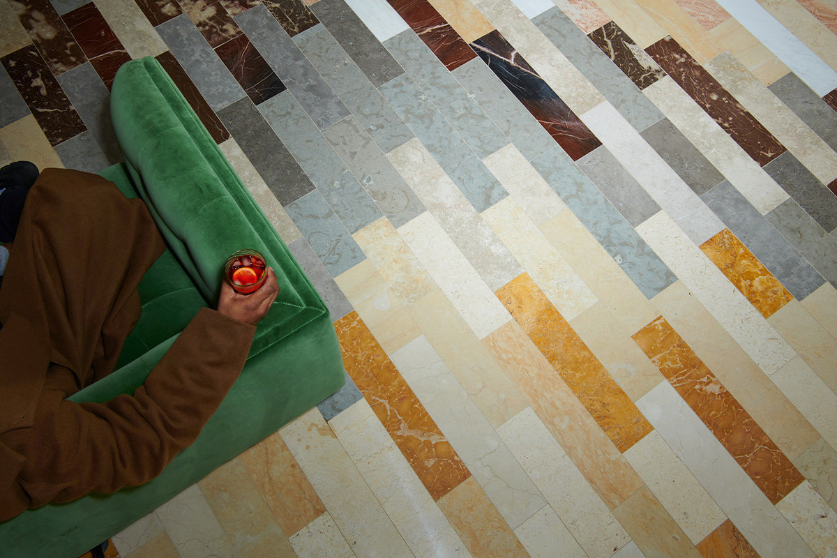 Overhead shot of multicolored tile floor featuring long rectangular stone tiles.
