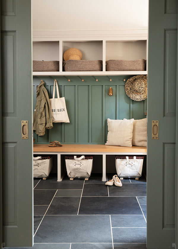 Stylish green walled mudroom with large slate mosaic tiles on floor.