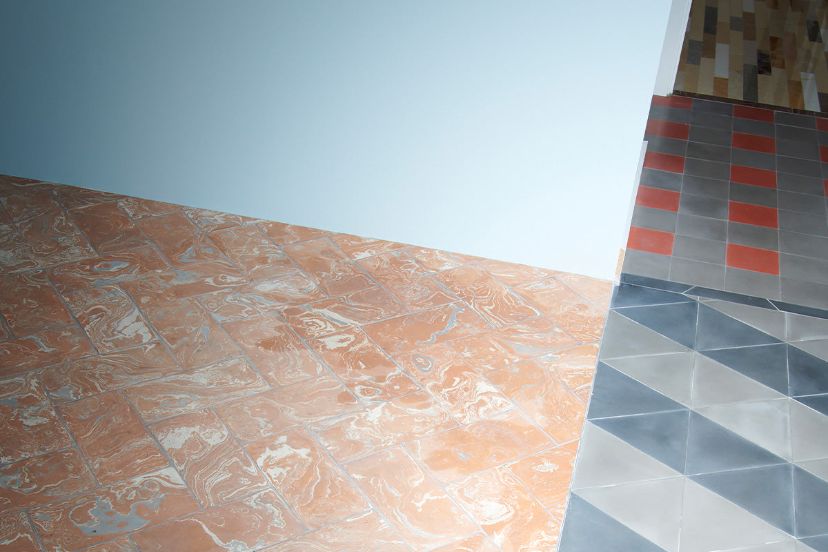 Overhead shot of marbled and cement tiles laid in three different floor areas.