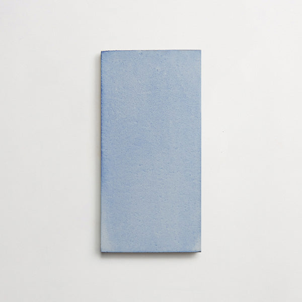One matte rectangular porcelain tile with a light blue finish against a white background.