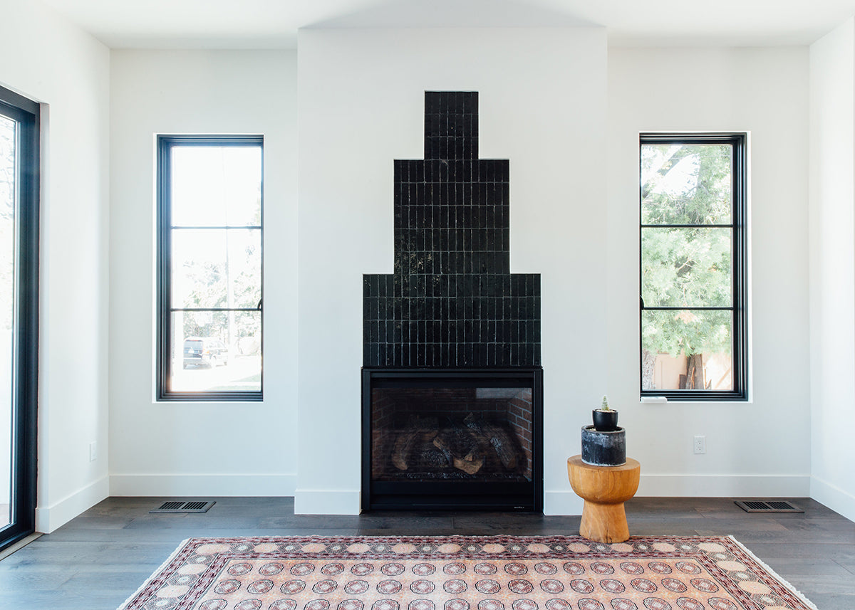 a modern living space and tiled fireplace featuring clé zellige bejmat tiles in scribes' ink