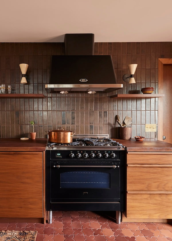 dark earth toned kitchen with dark brown glazed brick tile backsplash and wooden cabinets
