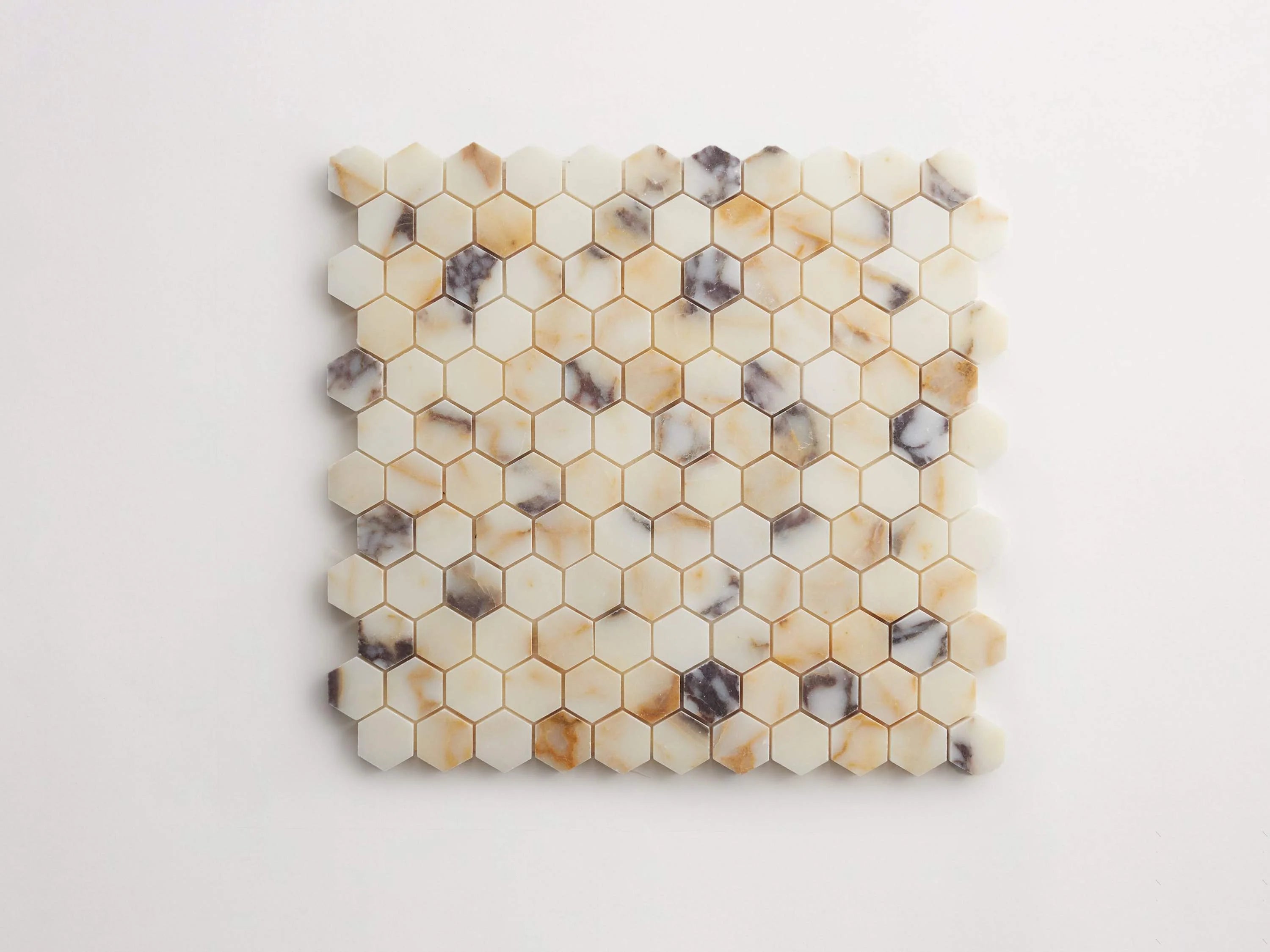 Flatlay of calacatta viola hex mosaic tile against white background.