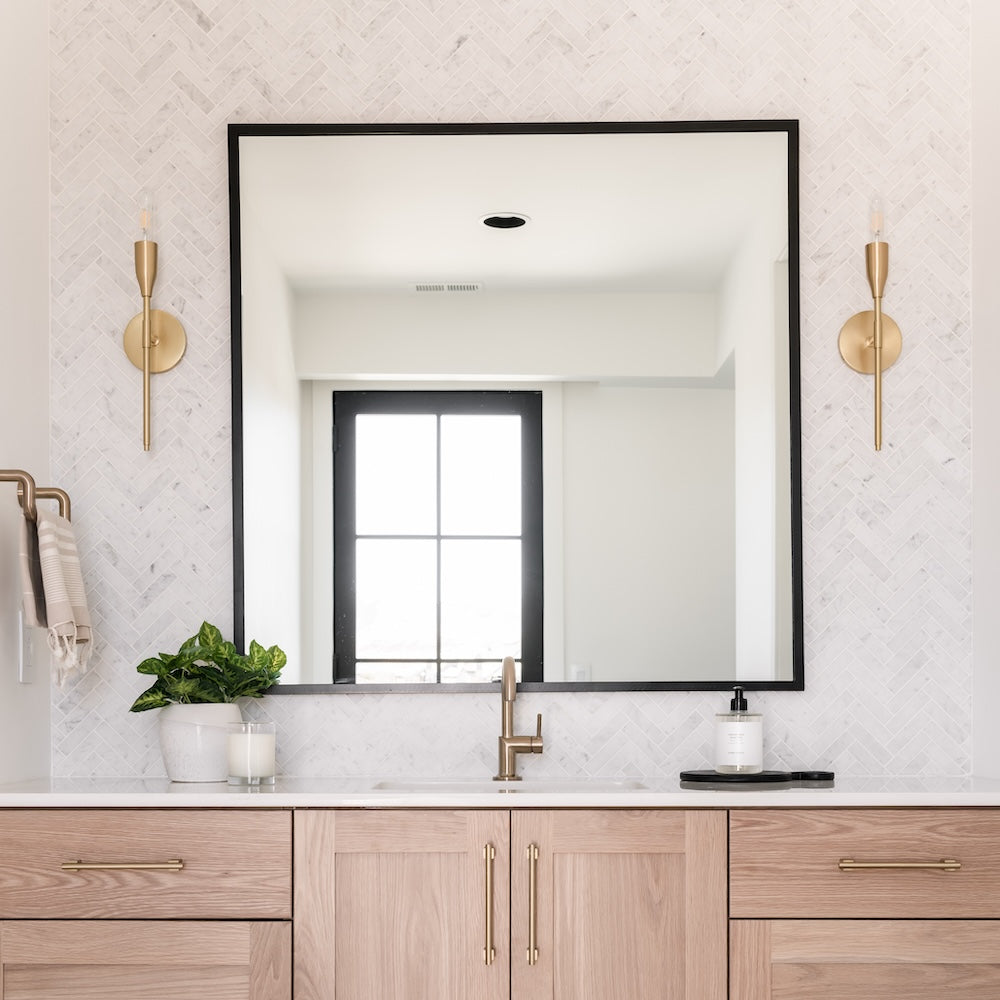 white herringbone marble vanity backsplash in modern airy bathroom
