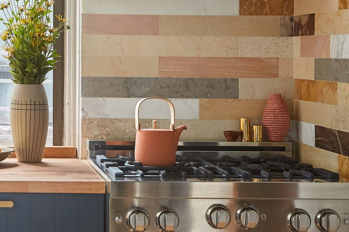 varied planks of stone tile on stove backsplash in eclectic kitchen