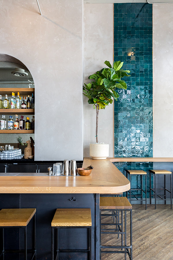 A contemporary restaurant with a blue/green tile wall accent.