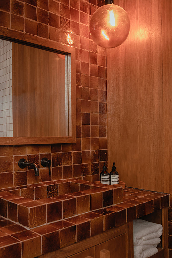 Dark red square tiles in a bathroom.