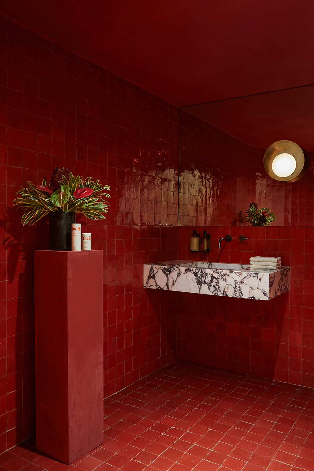 a show-stopping powder room bathroom featuring clé zellige square tiles in palace red installed on the walls, backsplash, and floor